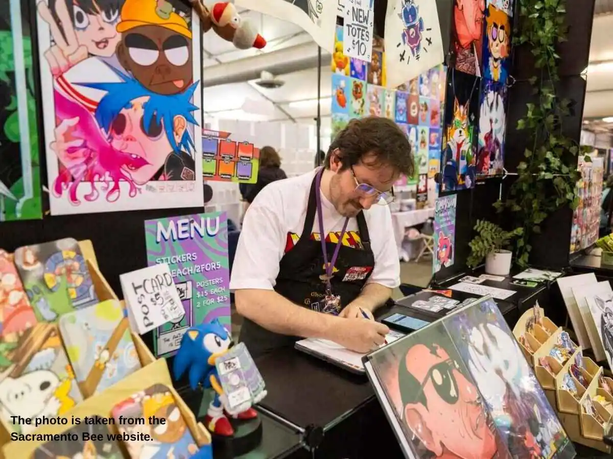 SacAnime  2026 exhibition stand in Sacramento with screen wall and merch counter at SAFE Credit Union Convention & Performing Arts District